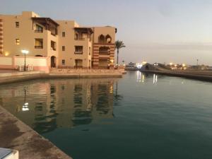 a building next to a body of water at بورتو غالب مرينا سيتي in Marsa Alam City