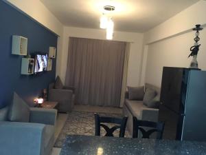 ein Wohnzimmer mit einem Sofa, Sofas und einem Tisch in der Unterkunft بورتو غالب مرينا سيتي in Marsa Alam City