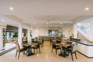 een restaurant met tafels en stoelen en een bar bij Legong Keraton Beach Hotel in Canggu