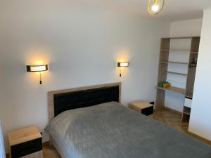 - une chambre avec un lit et deux lumières sur le mur dans l'établissement St Vélodrome 3 chambres parking 8 couchages neuf, à Marseille