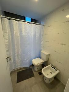 a bathroom with a toilet and a sink at Carlos Paz-Lake Towers in Villa Carlos Paz