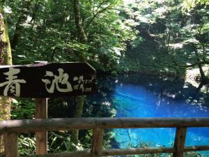 una señal frente a una cascada azul en Awone Shirakami Juniko en Fukaura