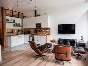 a living room with a couch and a table and chairs at Anouste Lou Bercail - cocon entièrement rénové avec vue sur la montagne in Campan