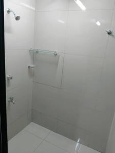La salle de bains est pourvue d'une douche avec une porte en verre. dans l'établissement Barrett Accommodation Apartment, à Suva