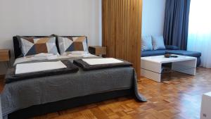 sypialnia z łóżkiem i niebieską kanapą w obiekcie BMM LUX APARTMENT w mieście Voždivac