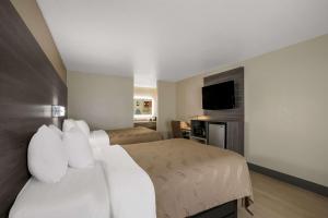 Habitación de hotel con 2 camas y TV de pantalla plana. en Quality Inn Commerce, en Commerce