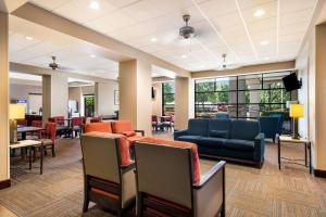 ein Wartezimmer mit Stühlen, einem Sofa und Tischen in der Unterkunft Comfort Suites Northlake in Charlotte