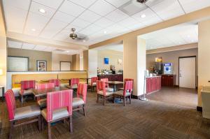 a dining room with tables and chairs and a kitchen at Comfort Suites Northlake in Charlotte