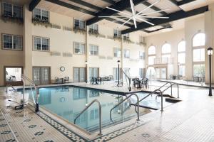 an indoor pool with tables and chairs in a building at Comfort Suites Milwaukee Airport in Oak Creek