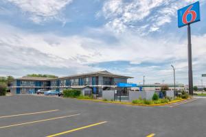 un edificio con un cartel delante de un aparcamiento en Motel 6 Jonesboro en Jonesboro