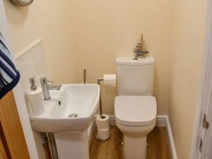 a small bathroom with a toilet and a sink at Sandy Toes in Mundesley