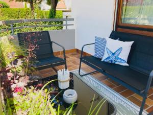 a patio with a blue bench and a glass table at Seebrise Ferienwohnung, Auszeit in ruhiger Lage, Bodensee Nähe, Privatparkplatz, Wlan, Smart TV in Rielasingen-Worblingen