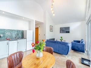 a kitchen and living room with a table and blue chairs at Greenacres Cabin in Coleford