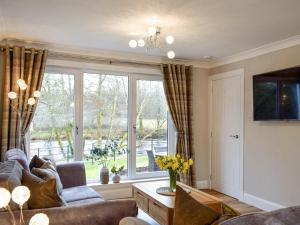 a living room with a couch and a large window at Teithbank in Callander