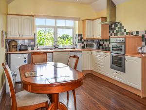 a kitchen with a wooden table and a wooden floor at The Old Farm Cottage in Louth