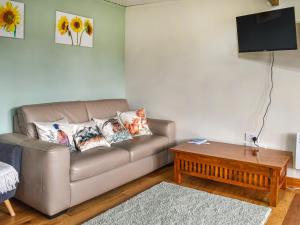 uma sala de estar com um sofá e uma mesa em Newlyn Cottage em Pluckley