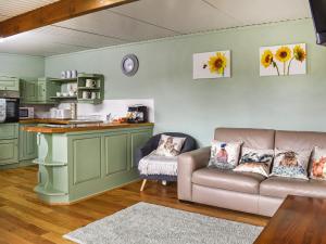 uma sala de estar com um sofá e uma cozinha em Newlyn Cottage em Pluckley