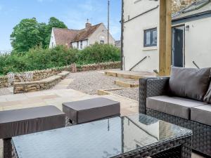un patio con sofá y mesa de cristal en South View en Castleside