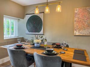 een eetkamer met een houten tafel en stoelen bij Red Robin Cottage in Wingerworth