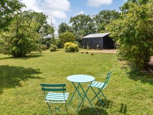 a table and chairs in a yard with a shed at Grove Cottage in Horham