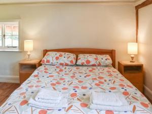 sypialnia z łóżkiem z poduszkami i 2 lampami w obiekcie Grove Cottage w mieście Horham