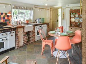 una cocina con mesa y sillas. en Grove Cottage en Horham