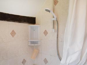 a shower with a shower curtain in a bathroom at Grove Cottage in Horham