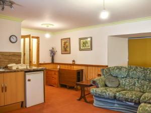 a living room with a couch and a kitchen at Hallgreen in Inverbervie