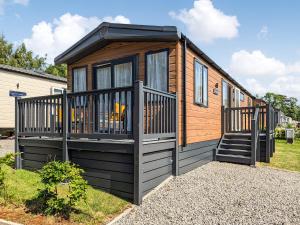 a tiny house with a porch and a staircase at Stonewood Country Lodge in Kelsall