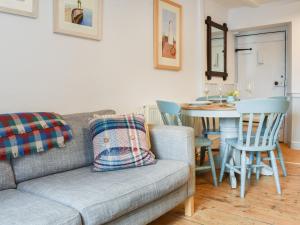 uma sala de estar com um sofá e uma mesa em Glenhowen em Robin Hood's Bay
