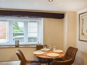 a dining room with a table and chairs and a window at The Old Buttery in Chulmleigh