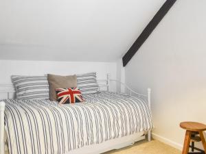 a bedroom with a bed with striped pillows at The Old Buttery in Chulmleigh