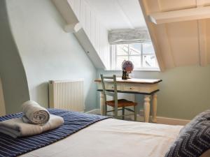 1 dormitorio con 1 cama y escritorio con silla en Glenhowen, en Robin Hood's Bay