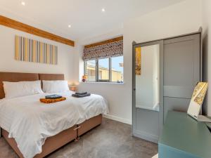 a bedroom with a bed and a window at The Granary - Uk44454 in Kingscote