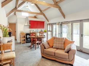 a living room with a couch and a kitchen at The Stables - Uk44477 in Kingscote