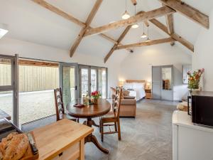 a kitchen and living room with a table and chairs at The Stables - Uk44477 in Kingscote