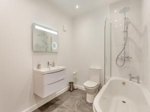 a white bathroom with a toilet and a sink at The Granary - Uk44454 in Kingscote