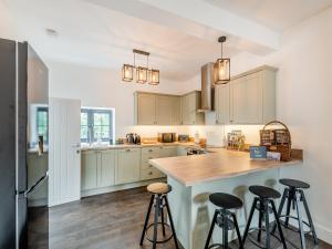 a kitchen with white cabinets and bar stools at South View in Castleside