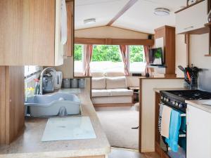 a kitchen with a sink and a couch in a caravan at Riverview in Dogdyke