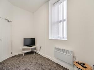 Jest to biały pokój z telewizorem i oknem. w obiekcie Number Four - Uk44899 w mieście Brierfield