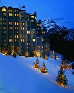 un gran edificio en la cima de una montaña cubierta de nieve en The Rimrock Resort Hotel Banff en Banff