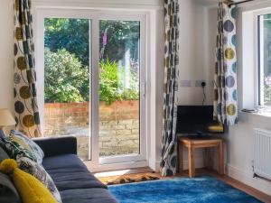 sala de estar con sofá y ventana en Skimming Stones en Sheringham