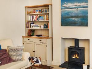 sala de estar con chimenea y estante de libros en Skimming Stones en Sheringham