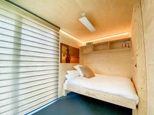 uma pequena cama num quarto com uma janela em The Studio em Yatton Keynell