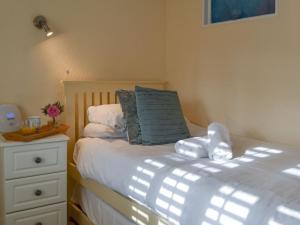a bedroom with a bed with a blue pillow and a dresser at Garden Cottage in Rottingdean