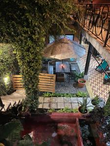 a patio with an umbrella and a pond at Amura Hostal in Antigua Guatemala