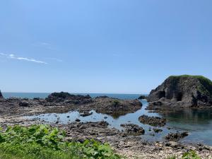 a body of water next to a rocky beach at Awone Shirakami Juniko in Fukaura