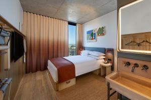 ein Hotelzimmer mit einem Bett und einem Fenster in der Unterkunft Moxy Sydney Airport in Sydney