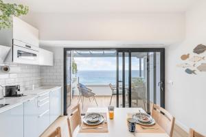 Una cocina con mesa y vista al mar. en Mirador del Atlántico, en Las Palmas de Gran Canaria