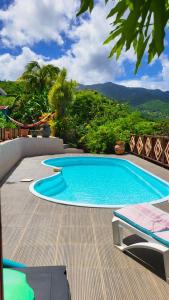 a swimming pool on a deck with a view of the mountains at VILLA TI'ROUCOU 3 étoiles - vue mer et piscine privée sans vis à vis in Bouillante